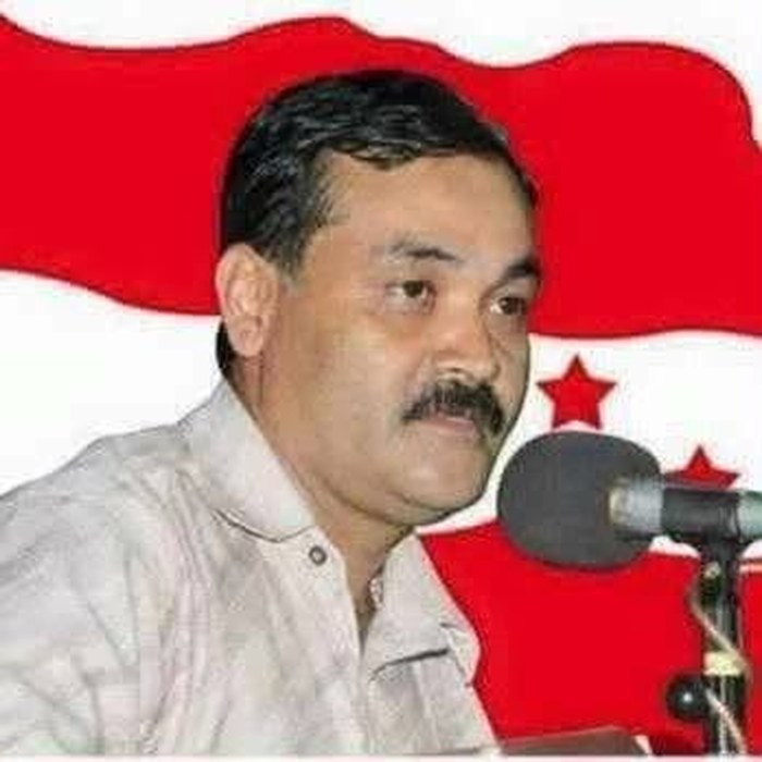 Deepak Babu Kandel speaking in front of a Nepali Congress flag
